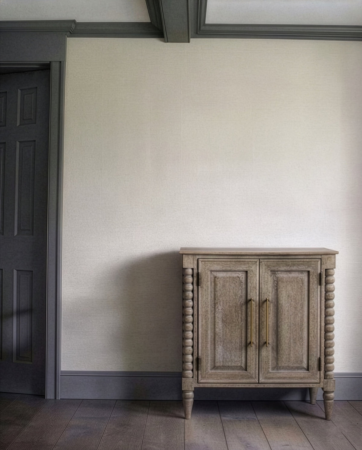 Bramley House end and side tables: a spool-turned two-door cabinet with brass handles standing against a plaster wall.