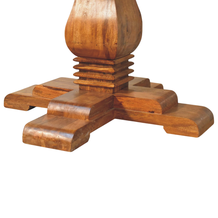 Close view of the sculpted base on the Ashford Round Pedestal Table in Chestnut.