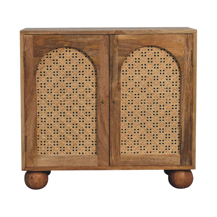 Comporta Arched Cane Cabinet in Amber with Natural Rattan, front view. 100% solid hardwood in a warm amber finish, two arched woven cane doors, brass knobs, turned ball feet.