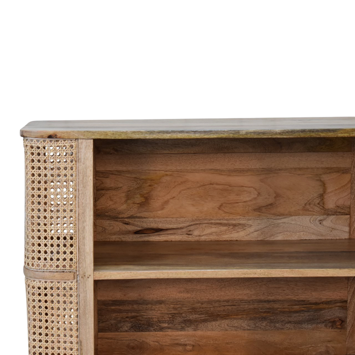 Close view of the shelf on the Comporta Open Cabinet in Amber with Natural Rattan.