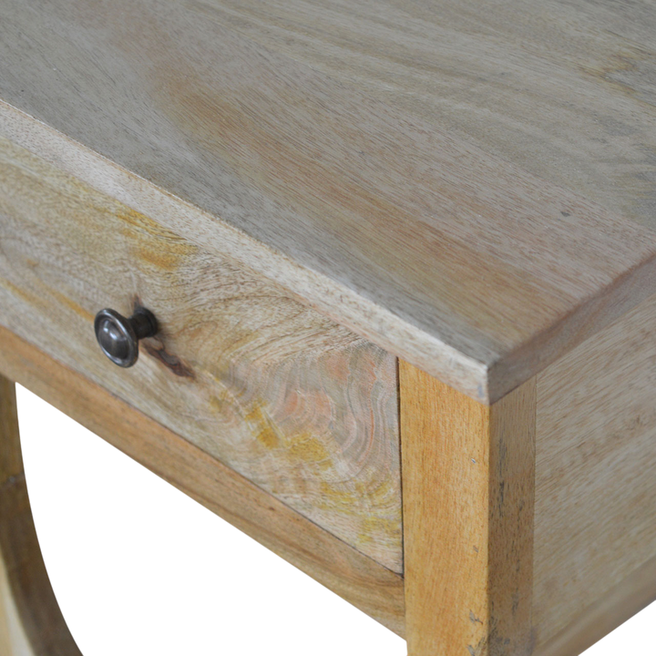 Close view of the drawer front on the Grosvenor Serpentine Bedside Table in Amber.