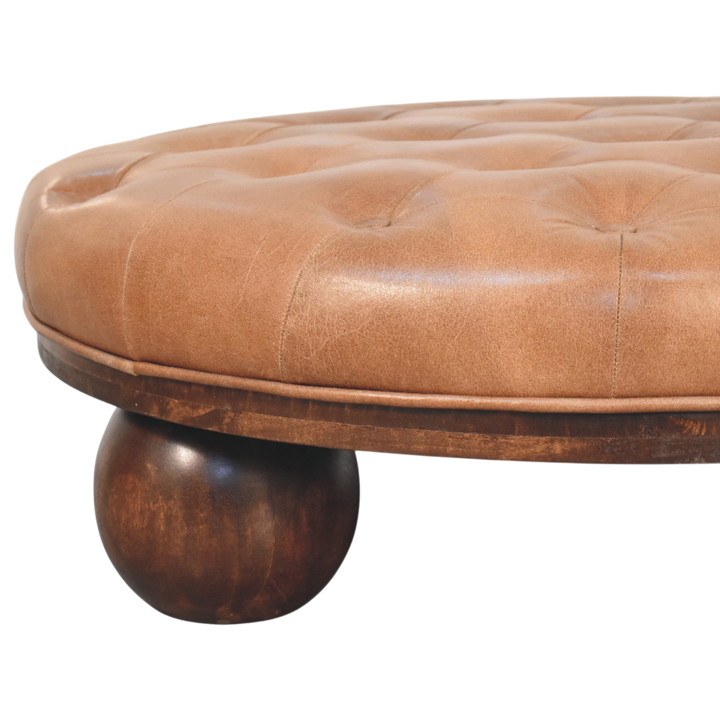 Close view of the feet on the Lucca Round Leather Coffee Table in Burnt Caramel.