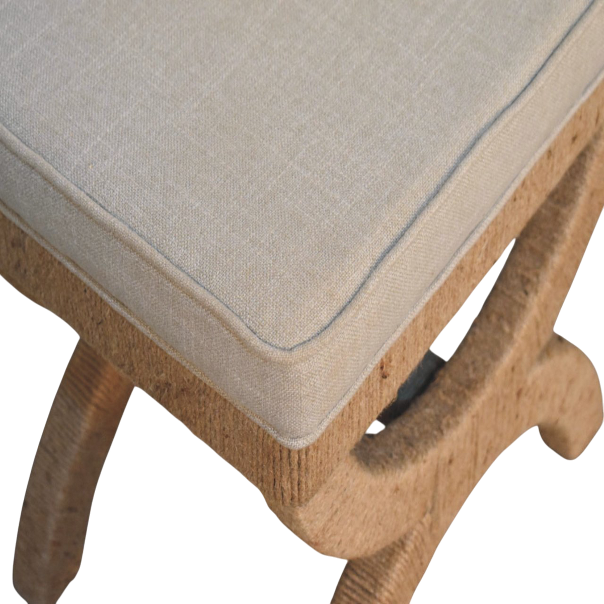 Close view of the hand-carved frame on the Serafina Curule Stool in Clay Linen.