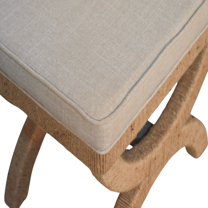 Close view of the hand-carved frame on the Serafina Curule Stool in Clay Linen.