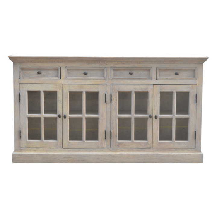 Sigtuna Glazed Sideboard with Drawers in Stone, front view. Solid hardwood throughout, caustic-washed to a pale weathered surface, four glazed doors shelved behind.