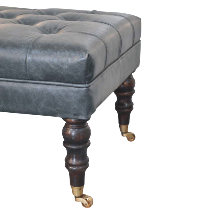 Close view of the brass castors on the Sussex Leather Bench Ottoman in Slate.