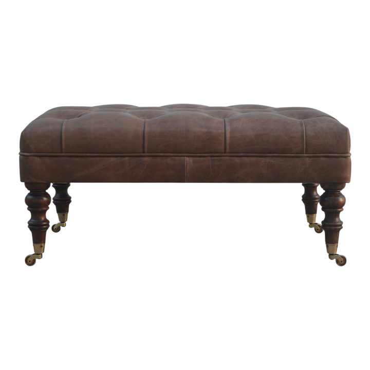 Sussex Leather Ottoman in Cocoa, front view. Cocoa leather over a solid hardwood frame, deep-buttoned top, hand-turned feet in a pale honeyed finish.