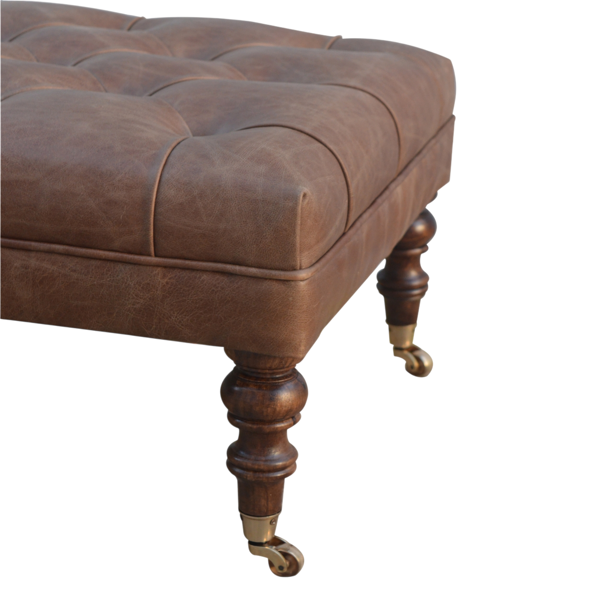 Close view of the turned legs on the Sussex Leather Ottoman in Cocoa.