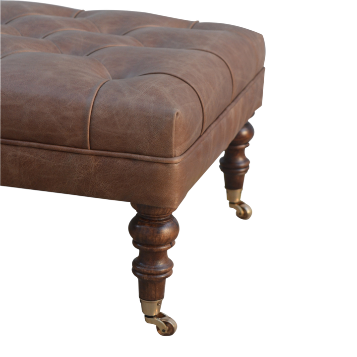 Close view of the turned legs on the Sussex Leather Ottoman in Cocoa.