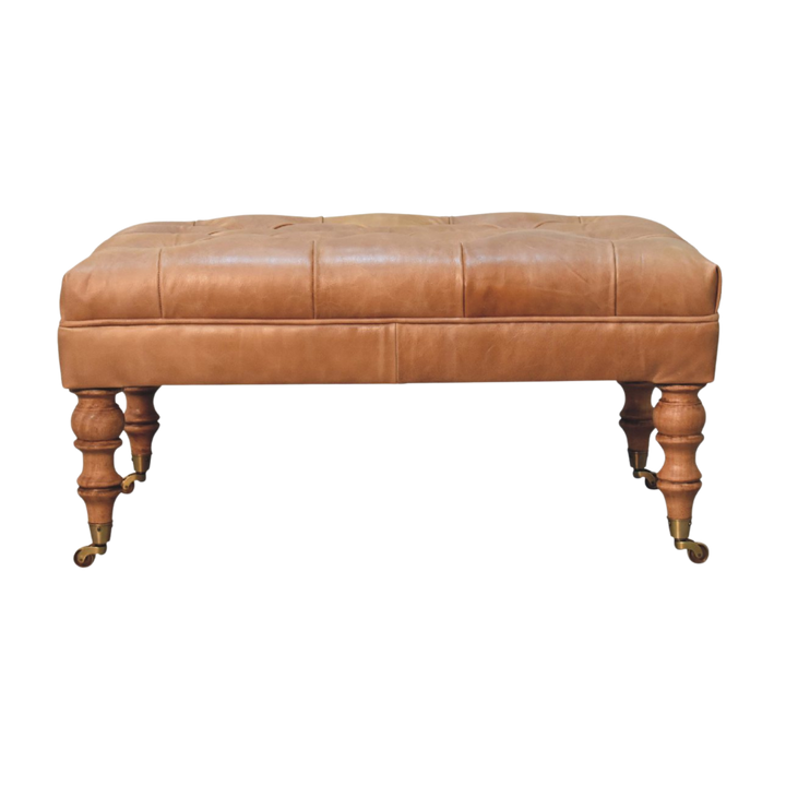 Sussex Leather Ottoman in Warm Biscuit, front view. Warm biscuit leather top on turned chestnut legs with brass castors.