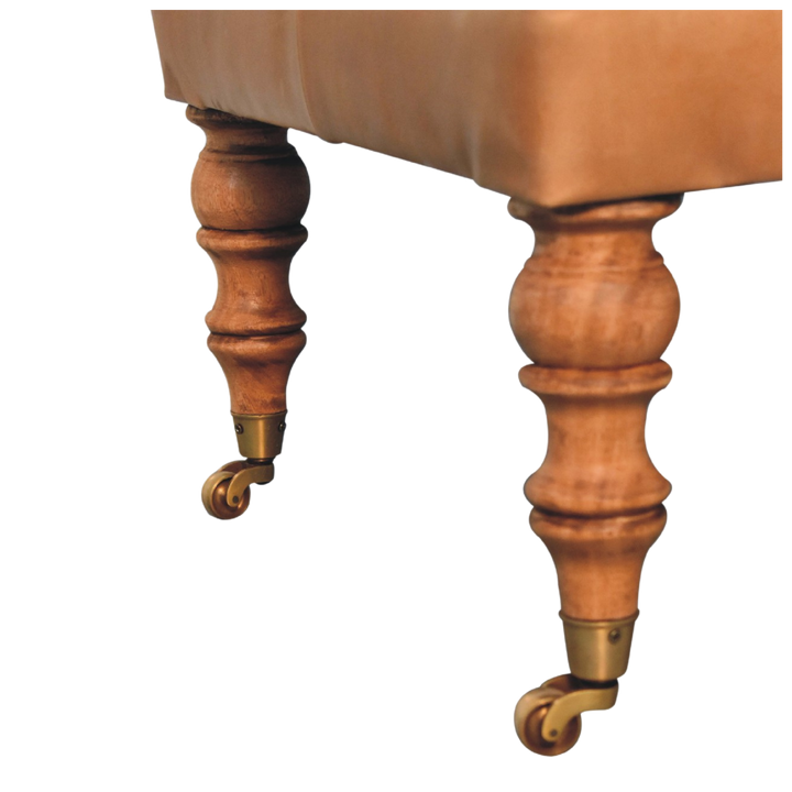 Close view of the turned chestnut legs and brass castors on the Sussex Leather Ottoman.