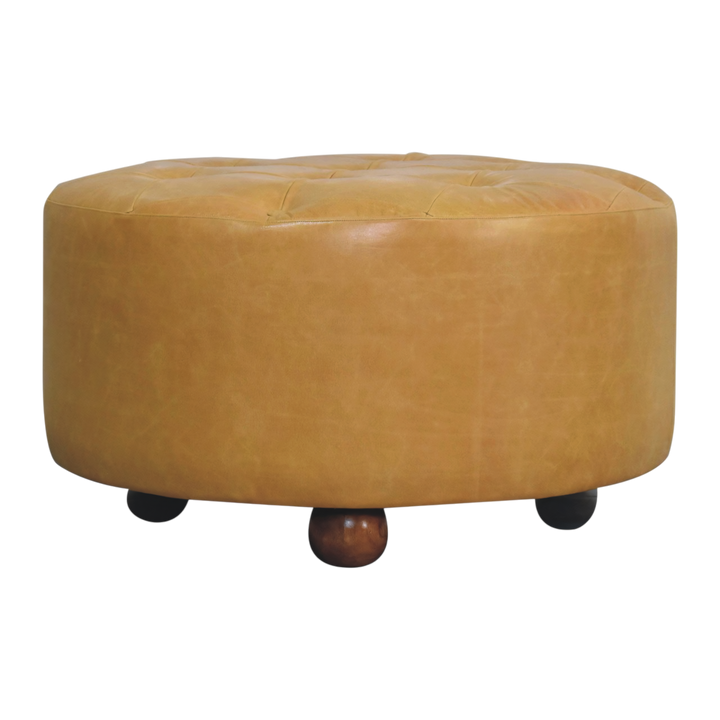Sussex Round Leather Coffee Table in Blonde Saddle, front view. Blonde saddle leather over a round solid hardwood frame, deep-buttoned top, turned ball feet.
