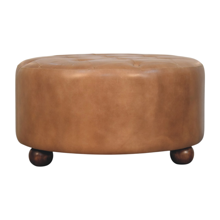 Sussex Round Leather Ottoman in Burnt Caramel, front view. Burnt caramel leather over a solid hardwood frame, hand-finished top with shallow tufting.