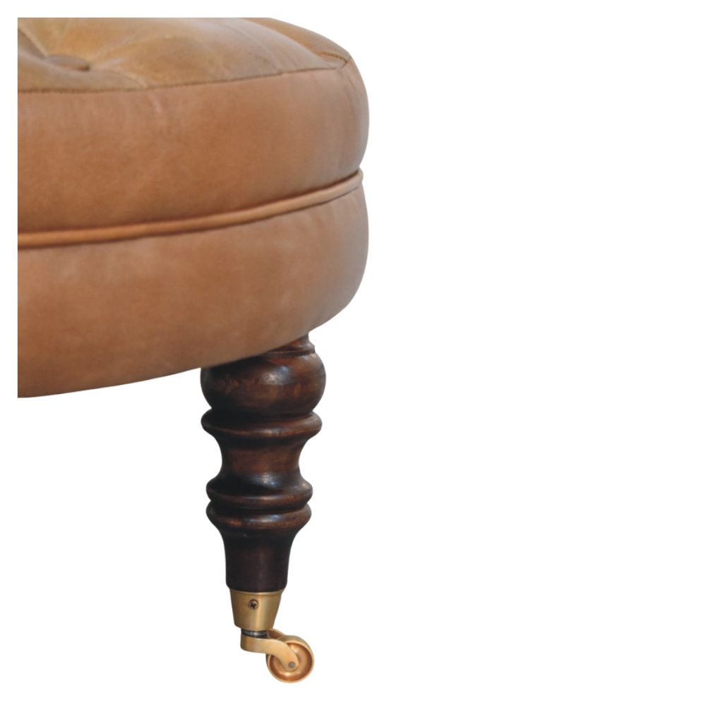 Close view of the leather stitching and chestnut leg joinery on the Sussex Round Leather Ottoman.