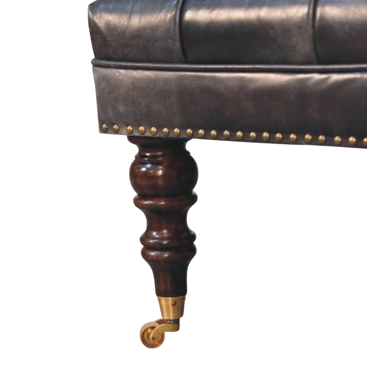 Close view of the turned legs and brass castors on the Sussex Square Leather Ottoman in Espresso.