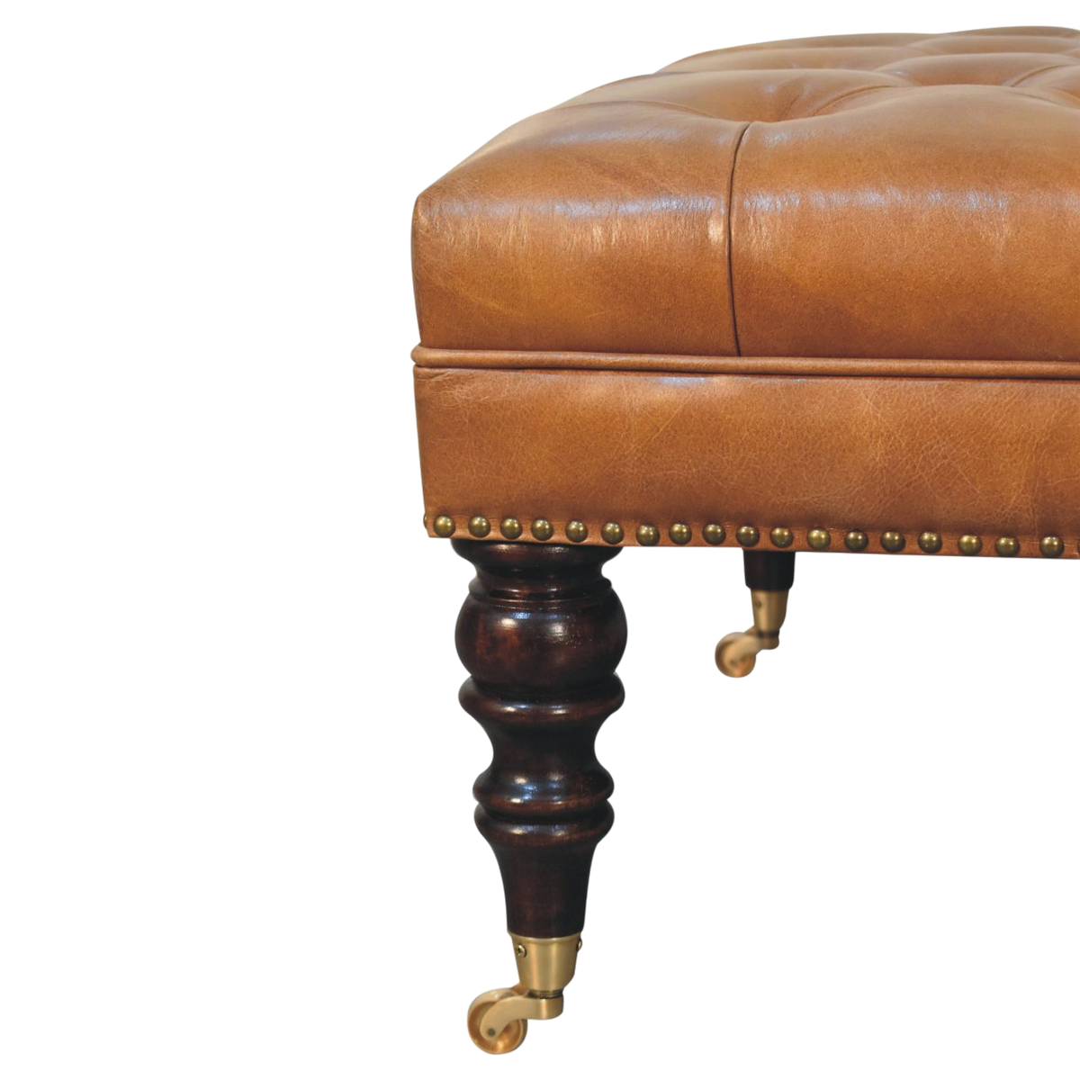 Close view of the brass castors on the Sussex Studded Leather Ottoman in Blonde Saddle.